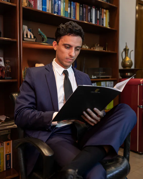 Dr. Caio Freitas analisando documentos em uma pasta da Caio Freitas Advocacia