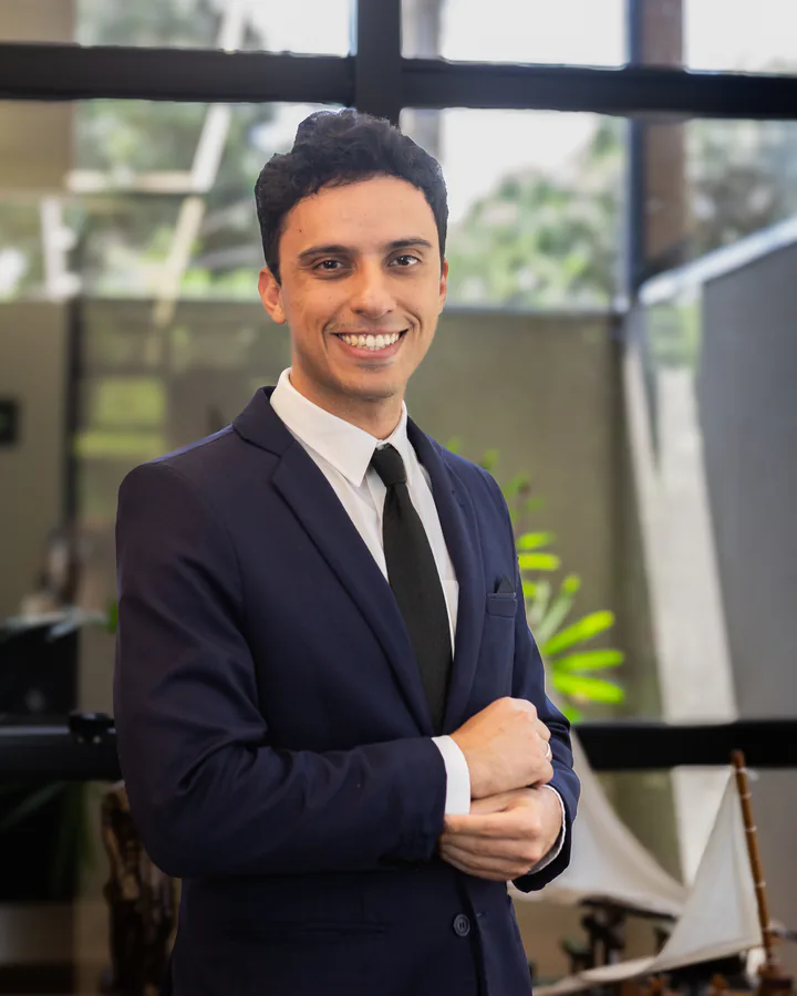 Dr. Caio Freitas, advogado imobiliário em Dourados, sorrindo no escritório